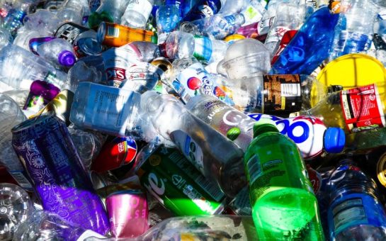 Discarded plastic bottles and cans of different colours and brands.