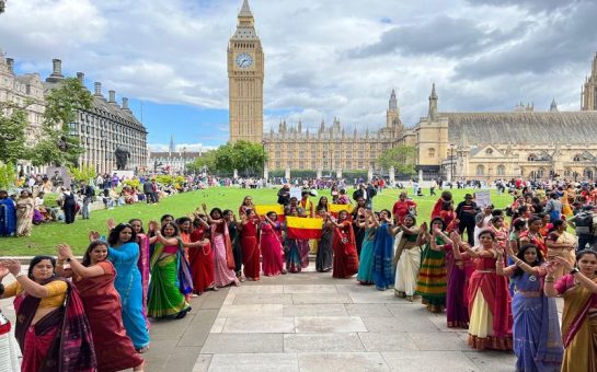 Women dressed in sarees (traditional Indian clothing) standing in front of Westminster.