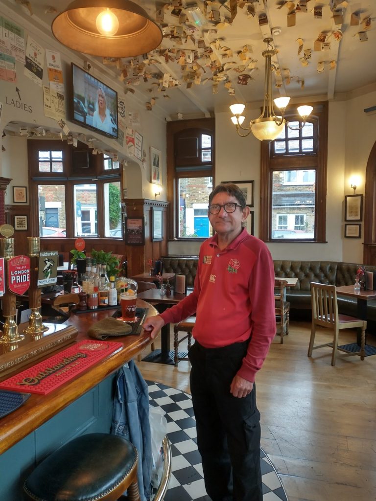 Regular Brian Overington stands at the bar under ticket-stub-covered ceiling