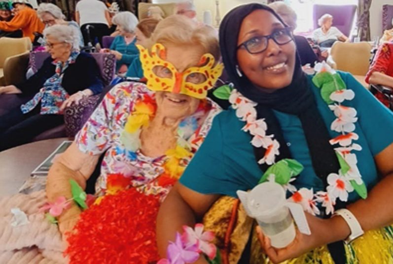 Two people sat smiling wearing carnival clothing