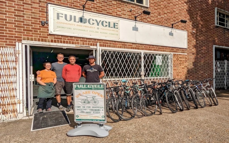 People standing in front of bike repair workshop