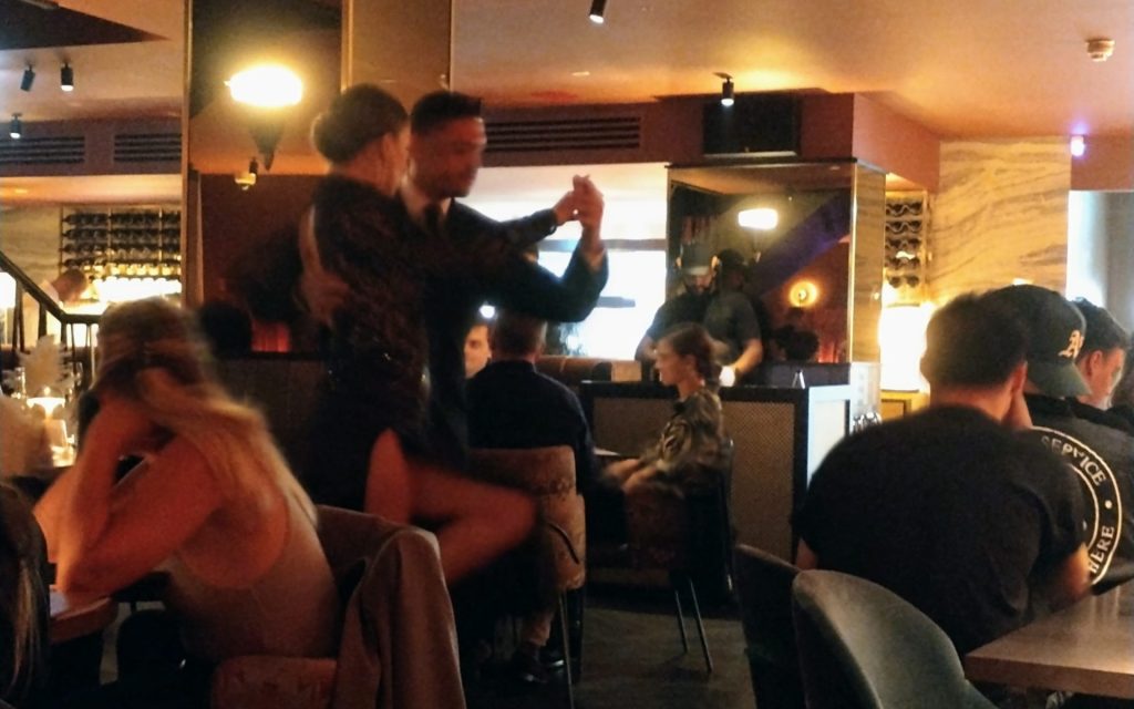 tango dancers between tables in restaurant