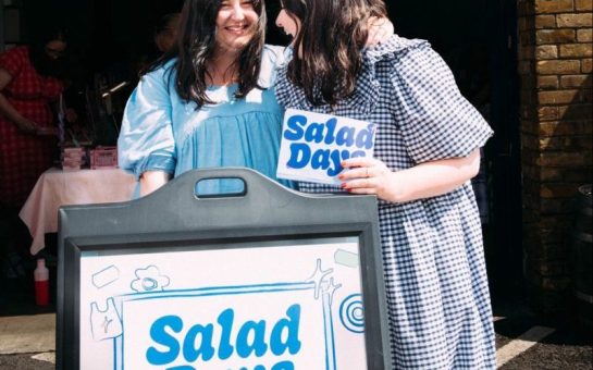 Tinker twins with a sign for their market