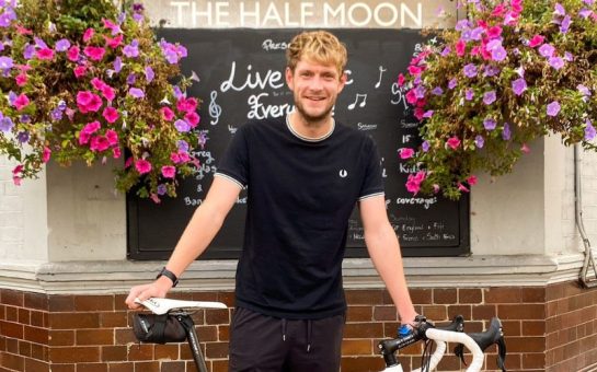Phil standing outside The Half Moon pub in Putney with his bicycle