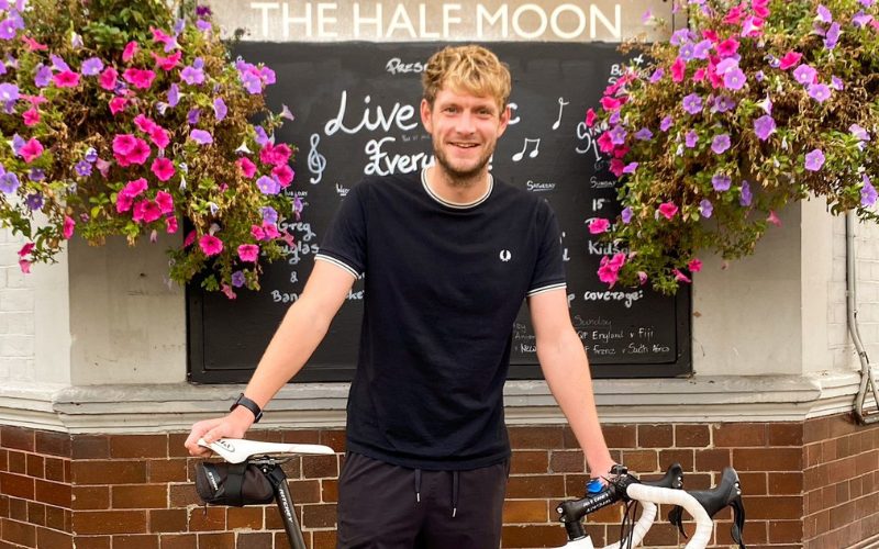 Phil standing outside The Half Moon pub in Putney with his bicycle