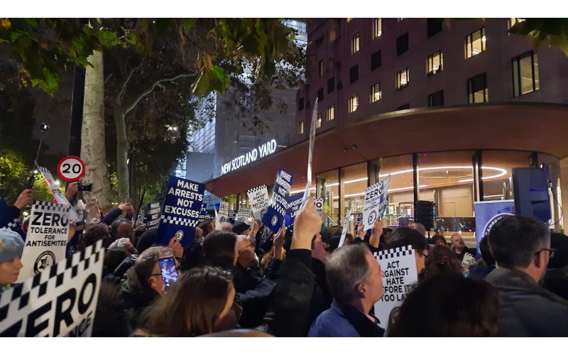 Protestors holding up signs that read 'Make arrests not excuses', 'Zero tolerance for antisemites' and 'Act against hate before its too late' outside New Scotland Yard