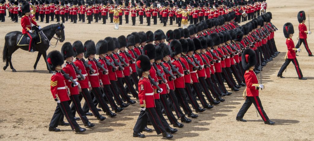 Image of King's Guards wearing their ceremonial bearskin caps marching in rows.