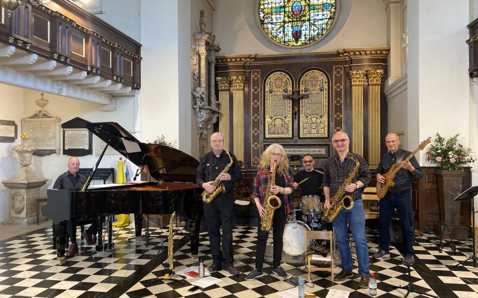 Senior Street Sextet band pictured together holding instruments in St Mary's Church, Twickenham