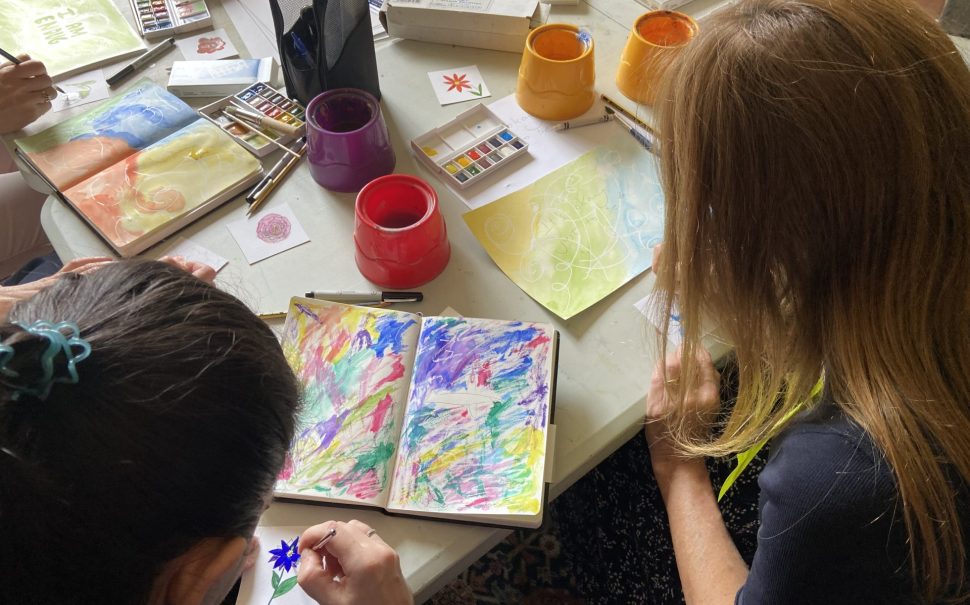 2 women painting in sketch books