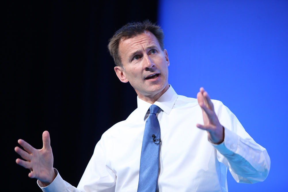 Chancellor of the Exchequer Jeremy Hunt is stood on stage delivering a speech ahead of the Autumn Statement