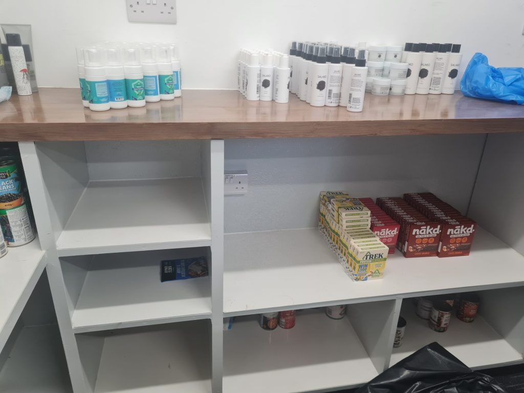 An image of shelves at the Brixton Soup Kitchen with very little food on them.