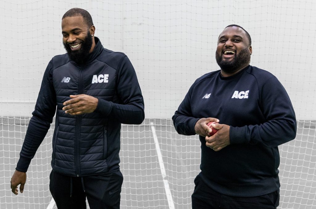 Picture of Community Coach Shamar Anderson and Director of Programmes Chevy Green. They are holding a cricket ball and laughing together.