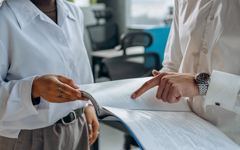 Two people pointing towards an report