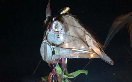 A festival of the dead mask sculpture made of paper and wood.