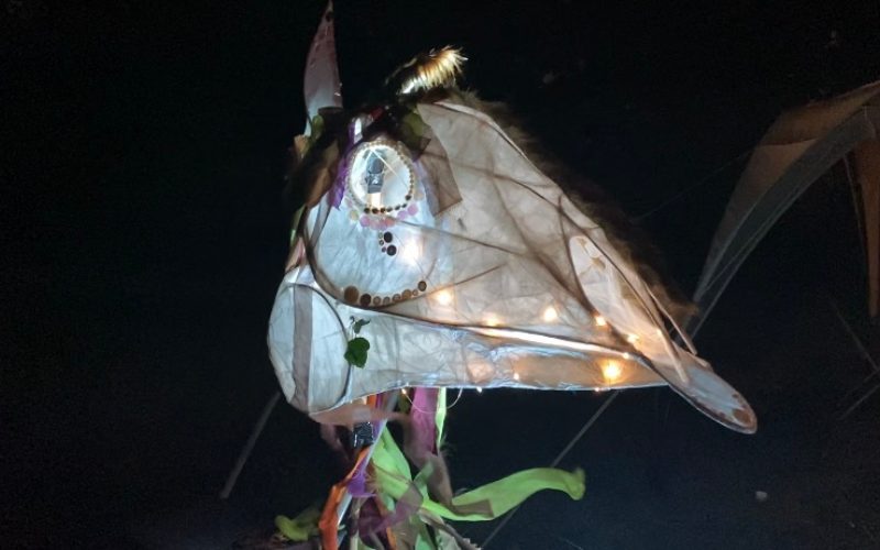 A festival of the dead mask sculpture made of paper and wood.