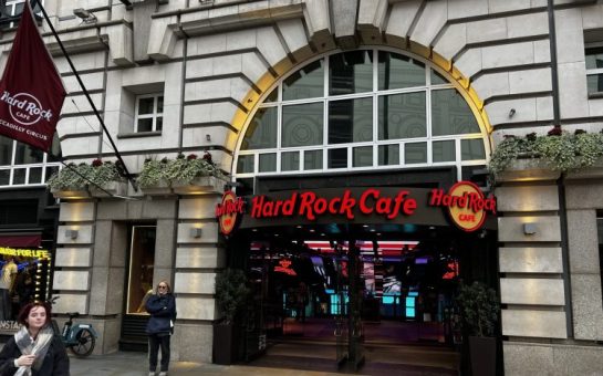 picture of the outside of Piccadilly Hard Rock Cafe.The Name is in bold red writing the brick is grey.