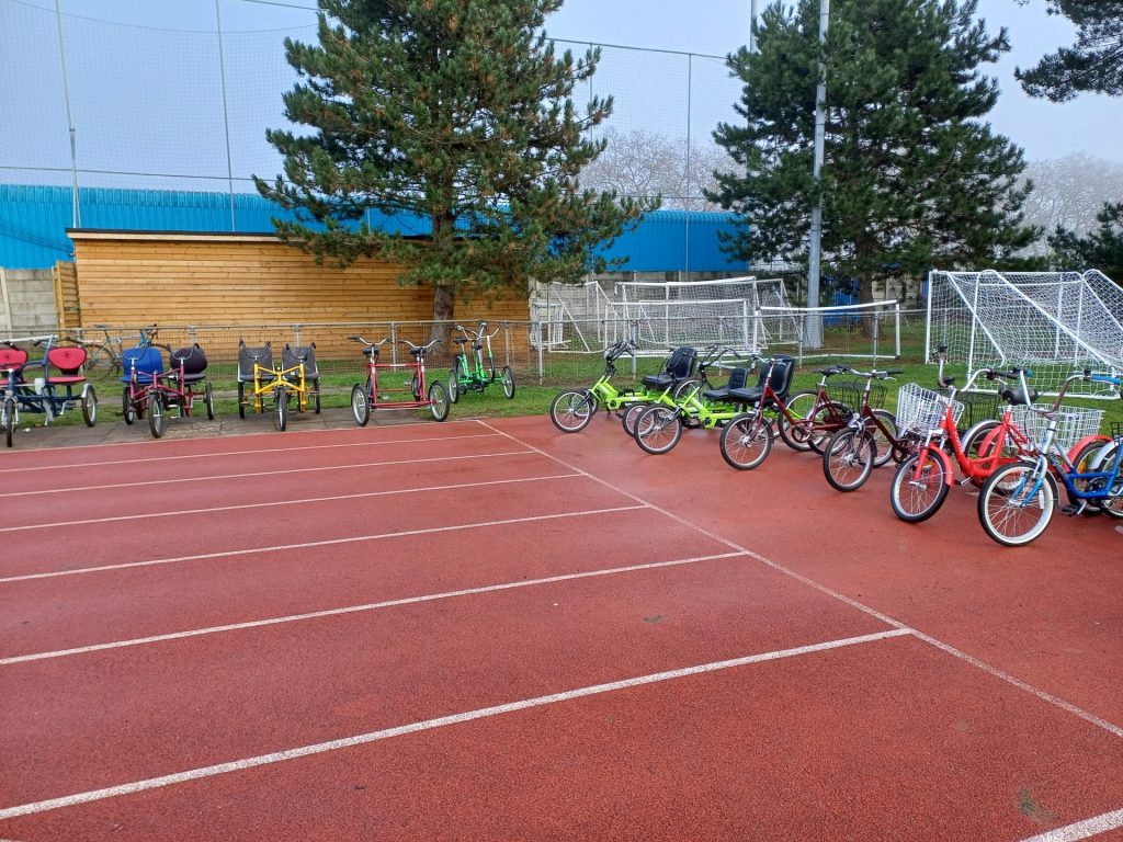 An athletics track with a range of adapted bikes and tricycles on display