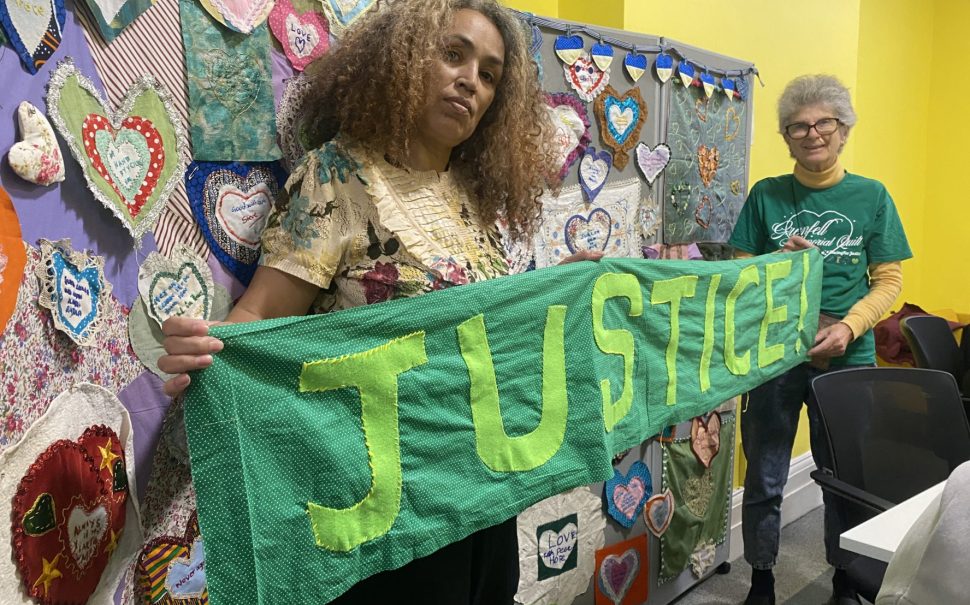 Grenfell Memorial Quilt volunteers holding a 'justice' sign