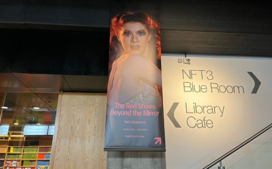 Banner for The Red Shoes: Beyond the Mirror hanging in the BFI: shows image of Moira Stewart from the film