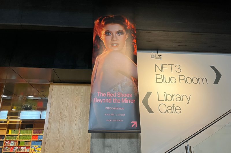 Banner for The Red Shoes: Beyond the Mirror hanging in the BFI: shows image of Moira Stewart from the film