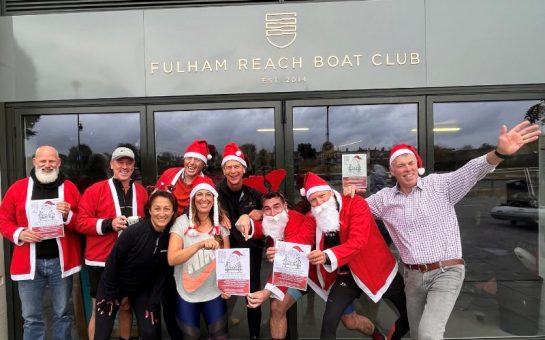 Group of people dressed in Christmas outfits outside Fulham Reach Boat Club.