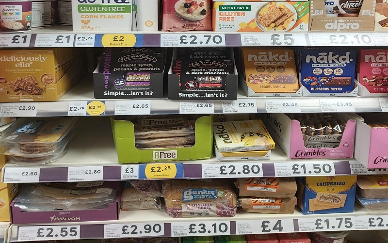 A picture of supermarket shelves holding a range of gluten free food, mainly bread and cereals.