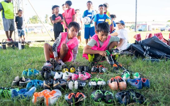 Marshallese children choose boots ahead of a training session on the island