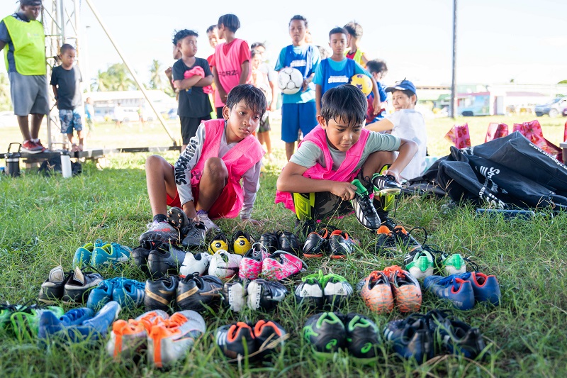 Marshallese children choose boots ahead of a training session on the island