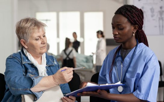 One person and a nurse/doctor speaking in a hospital