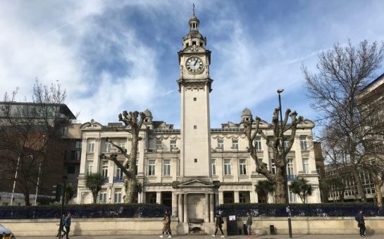 Front on photo of Queen Mary, University of London building with people walking past it