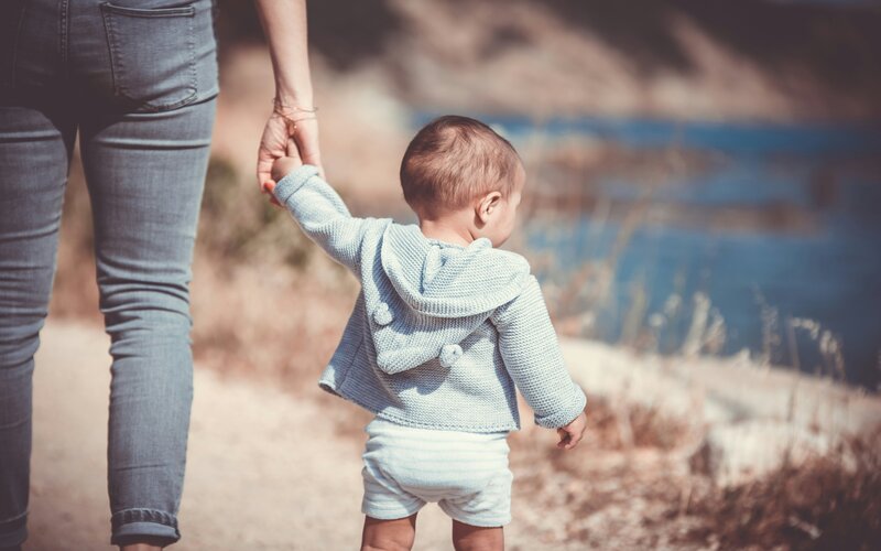 A young child having its hand being held