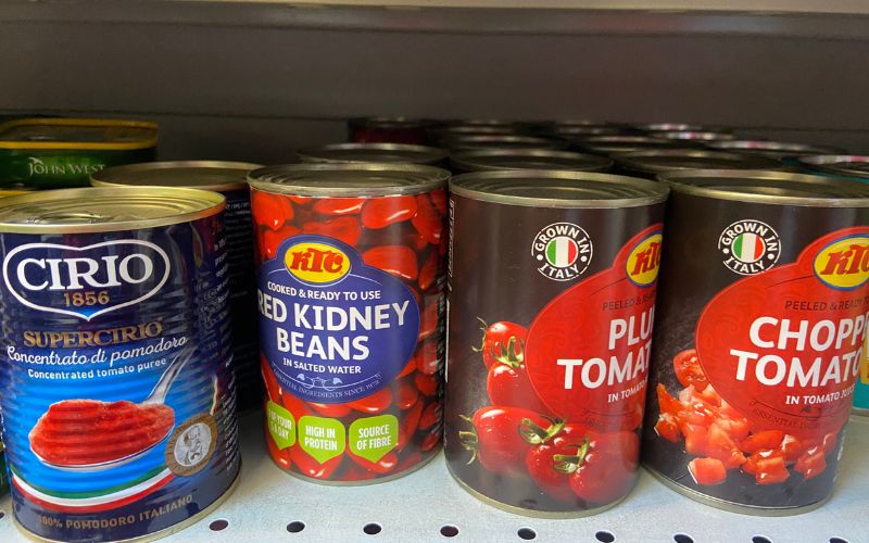 Four tins in a row. Three of chopped tomatos and one of kidney beans.