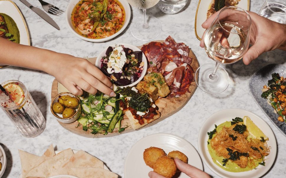 Plate of food with hands reaching in