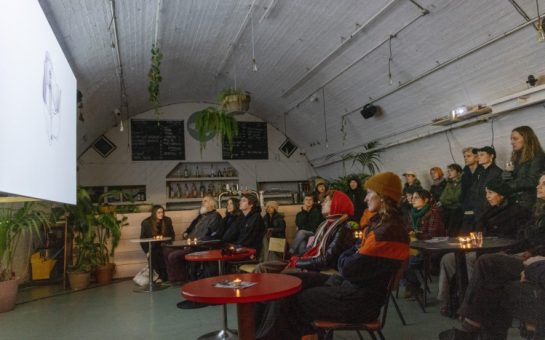 Room of people watching a film at Peckham Arches, London.