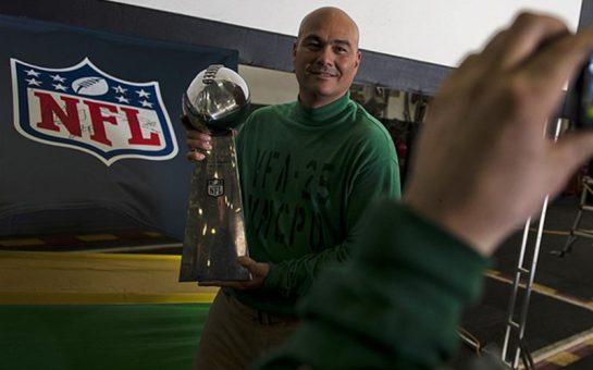 Master Chief Aviation Electronics Technician Robby Bonanno poses for a photo with the Vince Lombardi trophy in the hangar bay of the Nimitz-class aircraft carrier USS Carl Vinson