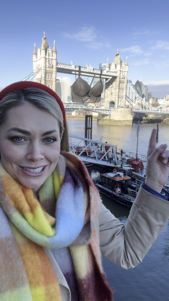 CGI Bra hanging from London's Tower Bridge with Georgia Jones pointing at it.