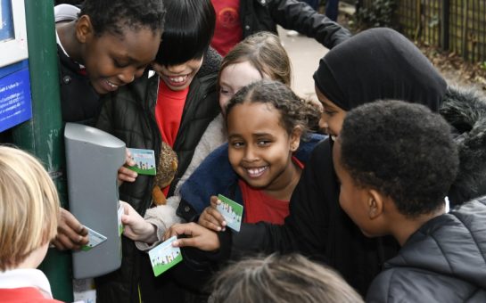 Eight students from Hammersmith & Fulham's Brackenbury Primary School stand around a lamppost with a Beep Box, a device used to record points in the Beat The Street exercise challenge