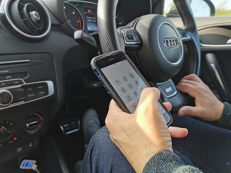 Driver using their phone while driving on the road