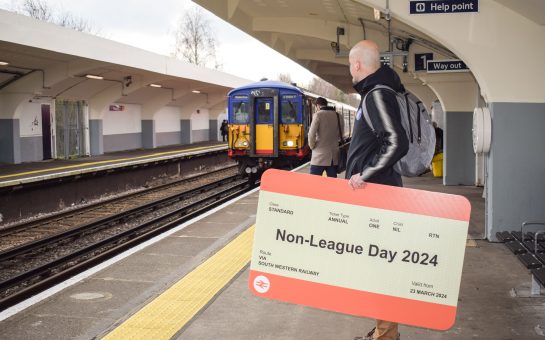 Non-League Founder James Doe waits for a train with a giant ticket outside Tolworth Station