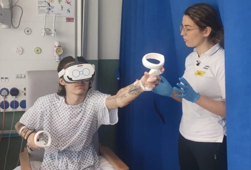 A young man doing physical therapy in hospital while wearing a virtual reality headset.
