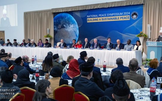 Guests at tables facing His Holiness as he delivers the keynote speech, with the head table to his right.