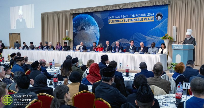 Guests at tables facing His Holiness as he delivers the keynote speech, with the head table to his right.