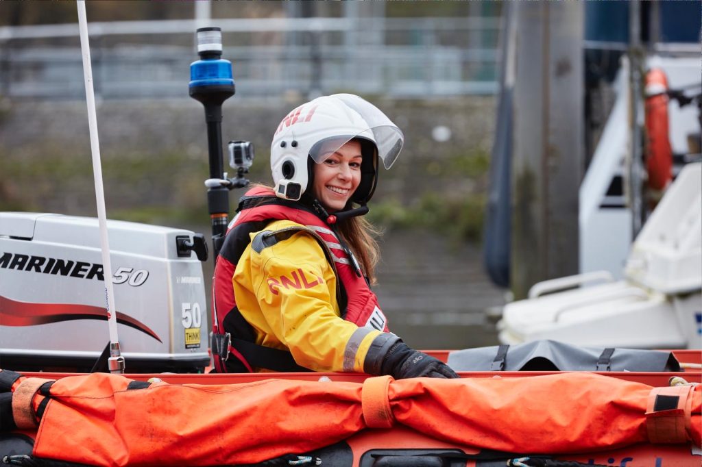 RNLI volunteer sat in lifeboat.