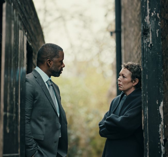 Olivia Colman stands next Adrian Lester either side of a doorway in a shot from the film Before Our Eyes. They look serious.