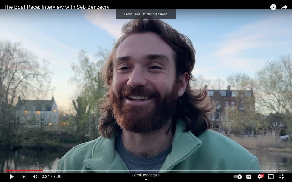 A smiling photo of the Cambridge Blue Boat captain, Seb Benzecry. He is in the foreground, with trees and houses in the background.