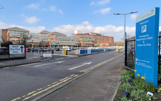 Image shows St George's hospital building and car park with an entrance sign reading 'Emergency Department (A&E)'.
