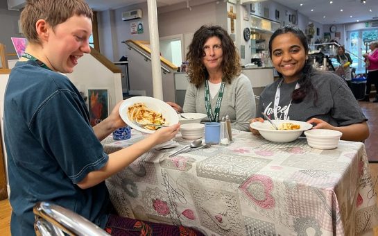 Three people around a table eating food