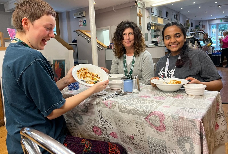 Three people around a table eating food