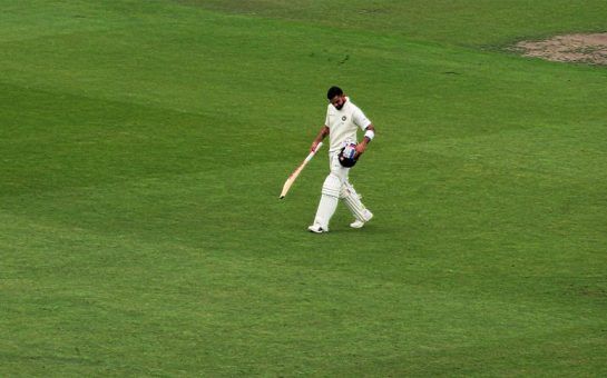 Virat Kohli walking off a cricket pitch