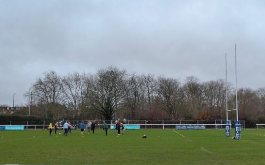 Players warming up at Age UK Richmond's walking rugby class at Richmond Rugby club